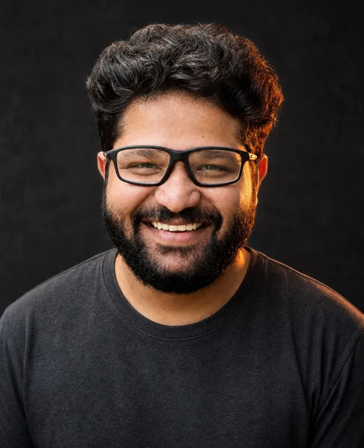 Vikas Kapadiya smiling against a dark background